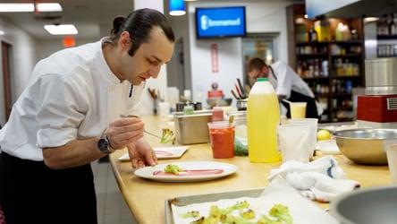 Chef plating food in an Immanuel kitchen