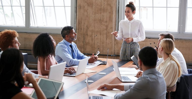 Group of employees at a meeting listening to a person presenting