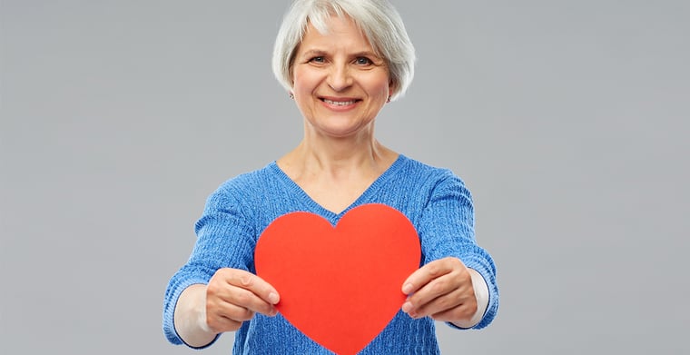 elderly woman holding a red heart