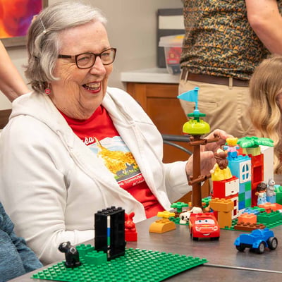 A senior woman participating in LEGO® therapeutic programming.