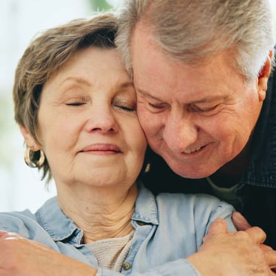 A senior couple hugging.
