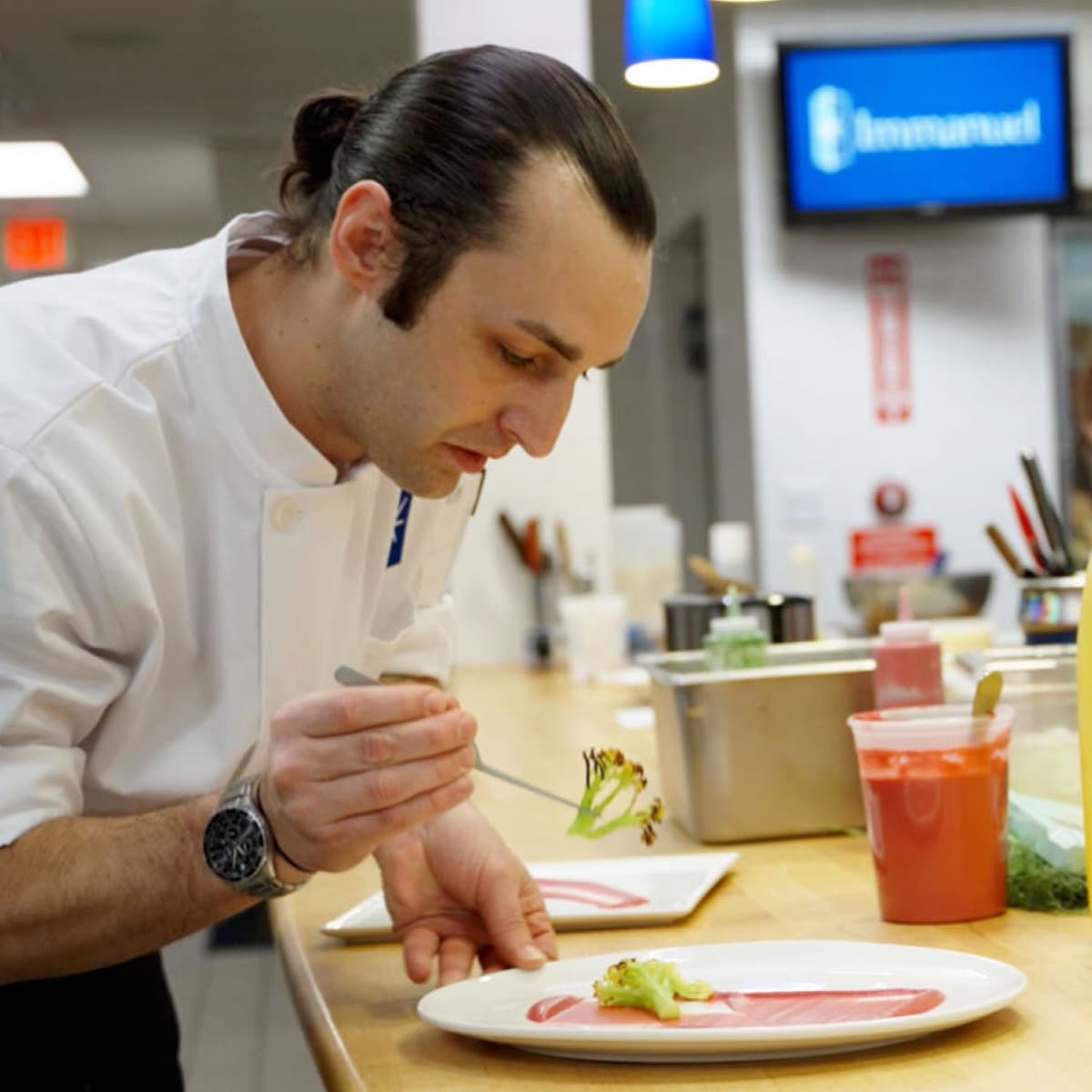 An Immanuel chef works to place food items on a dinner plate.