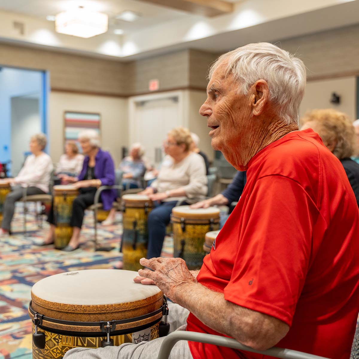 A resident plays the hand drums during a social drumming session.