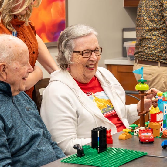 A senior woman in a memory support community participates in a LEGO® enrichment activity.