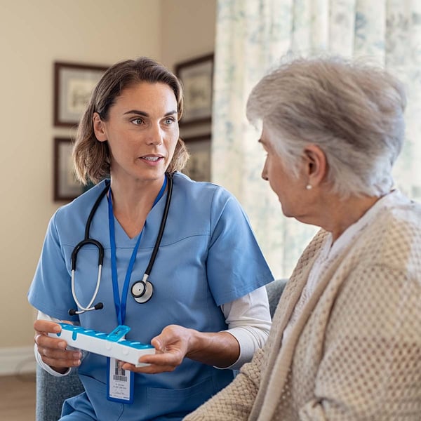 A nurse talks with a female senior about her medication.