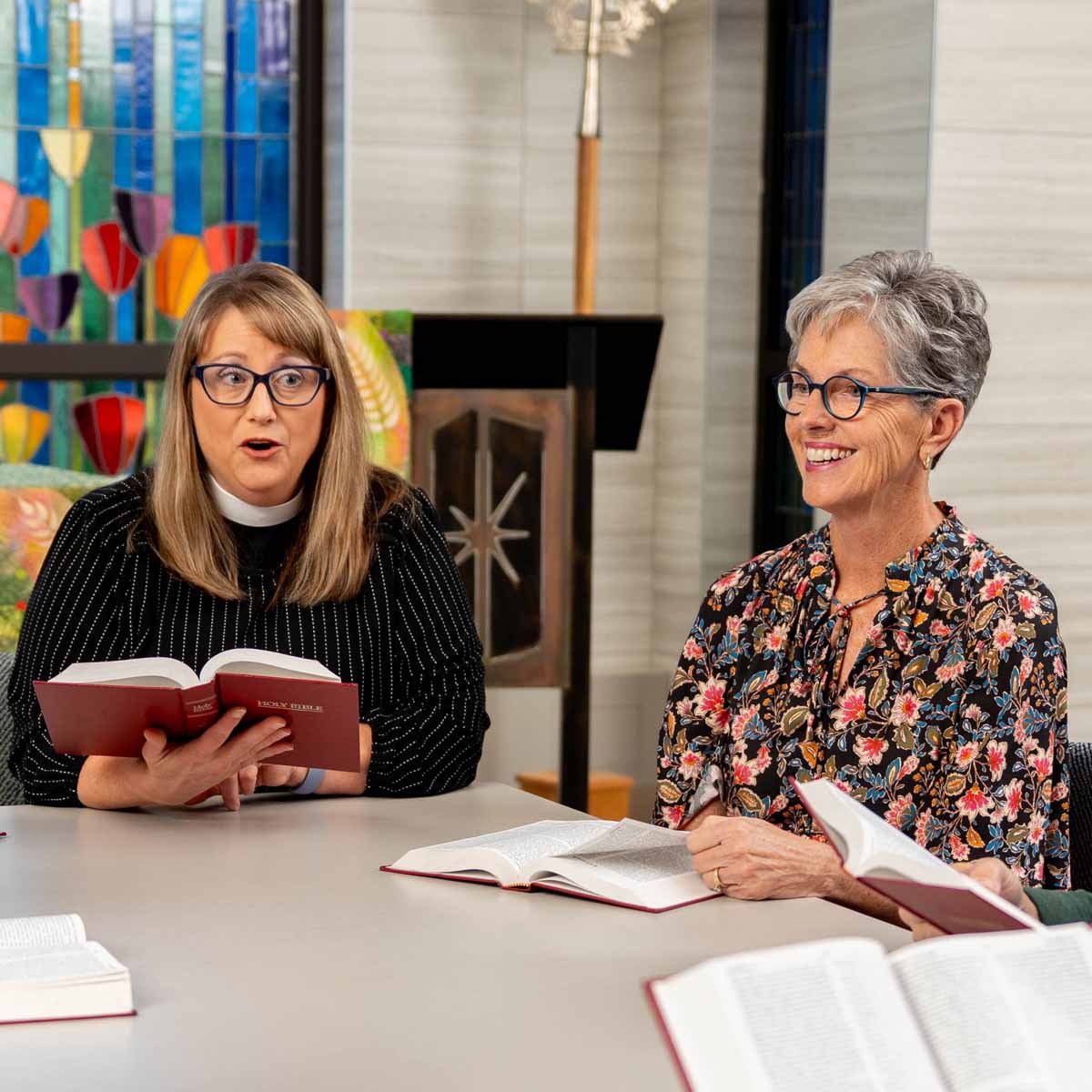 A pastor and senior woman participate in Bible study.