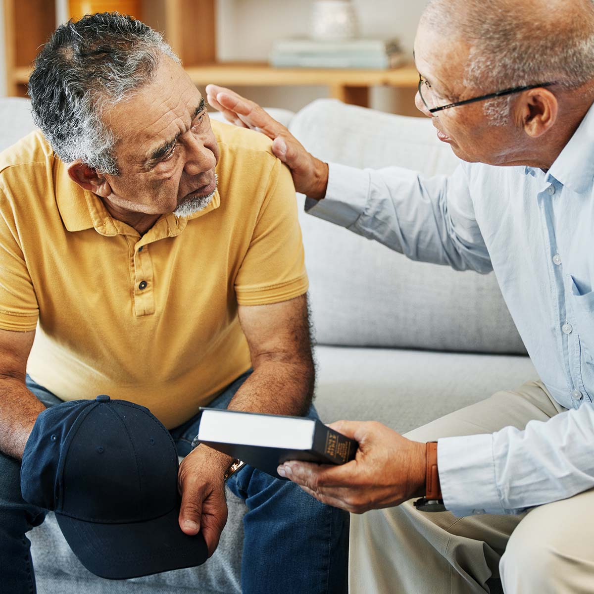 A pastor provides support to a male senior.