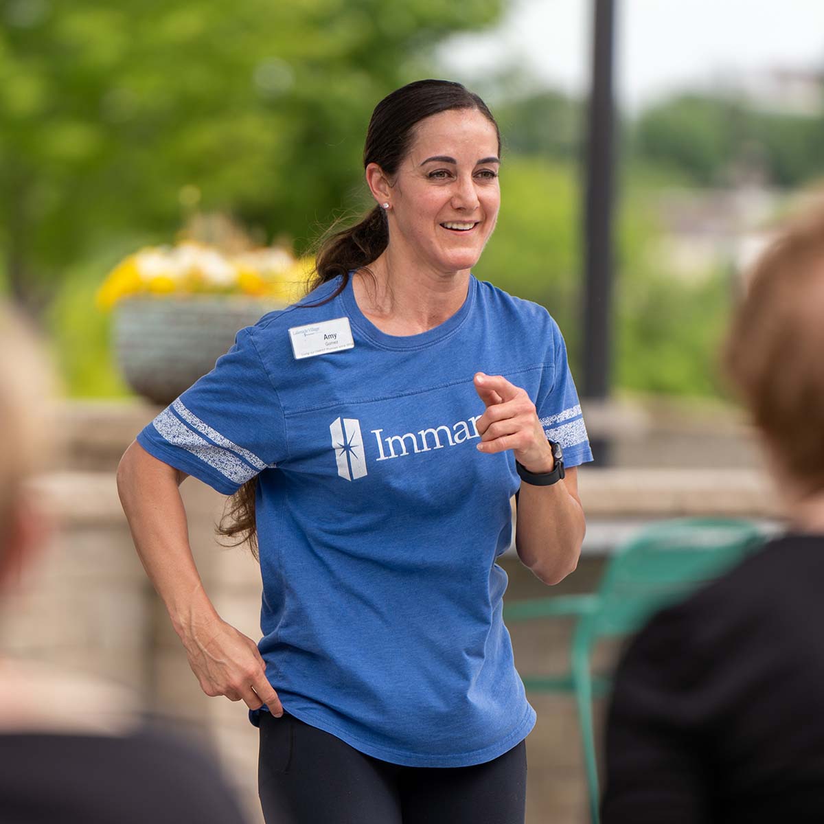 An Immanuel wellness employee leads an exercise session on a patio.