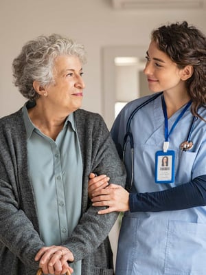 A nurse comforts and walks with a senior.