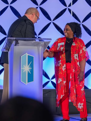 A female Immanuel employee receives an award on stage.