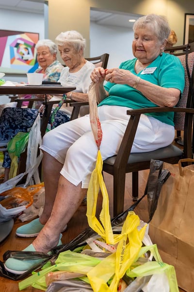 Residents at Pacific Springs in Omaha transform recycled plastic bags into lightweight sleeping mats for people experiencing homelessness.