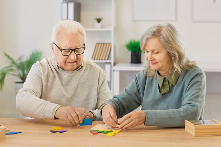 A senior couple work together on a puzzle.