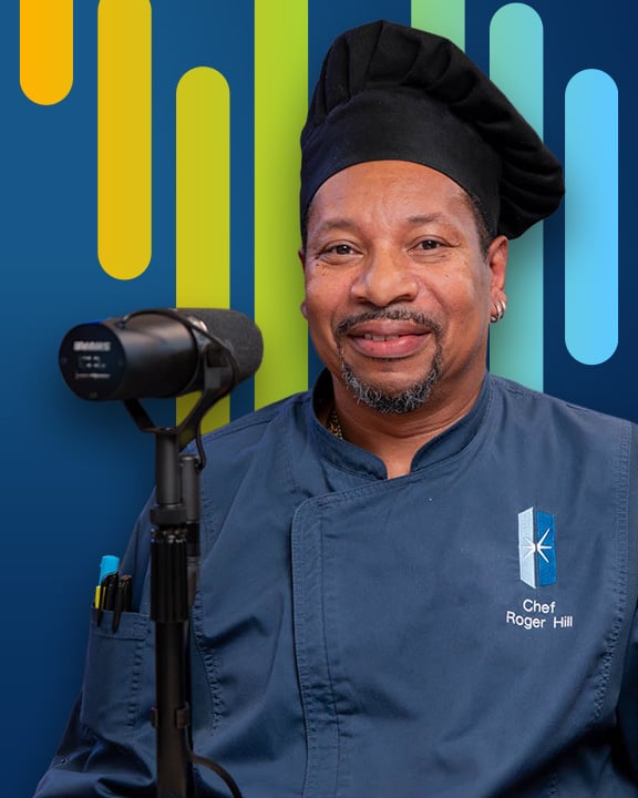 Roger Hill smiling next to a microphone