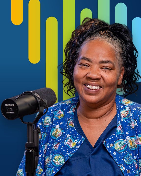 Tenetha Collins smiling next to a microphone