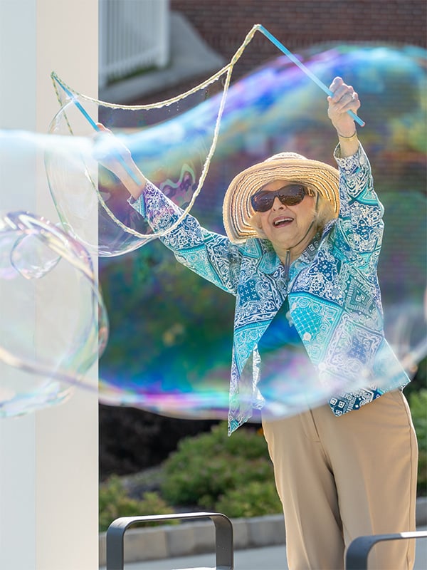 Senior woman playing with bubbles.
