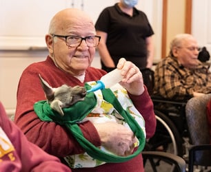 Immanuel instructor supporting elderly woman rock climb.