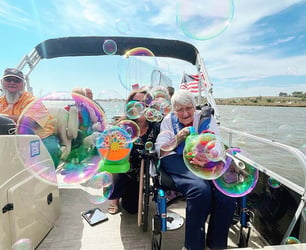 A group of seniors are on a boat during a recreational therapy group outing.