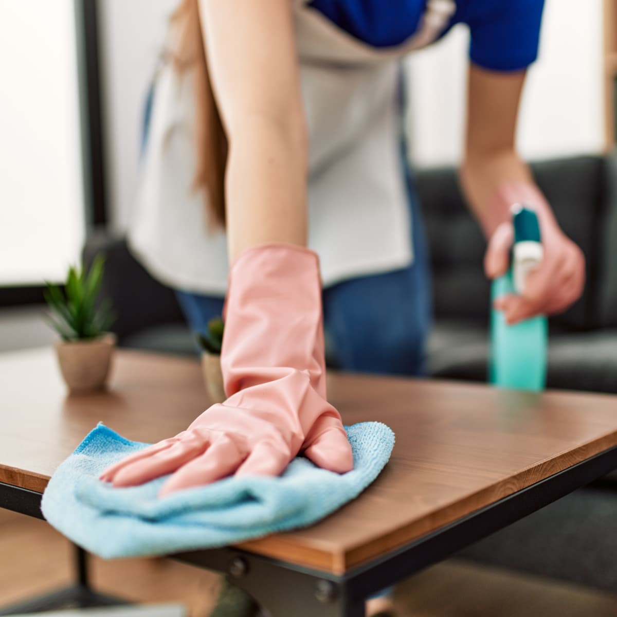 Close up of woman cleaning a table.