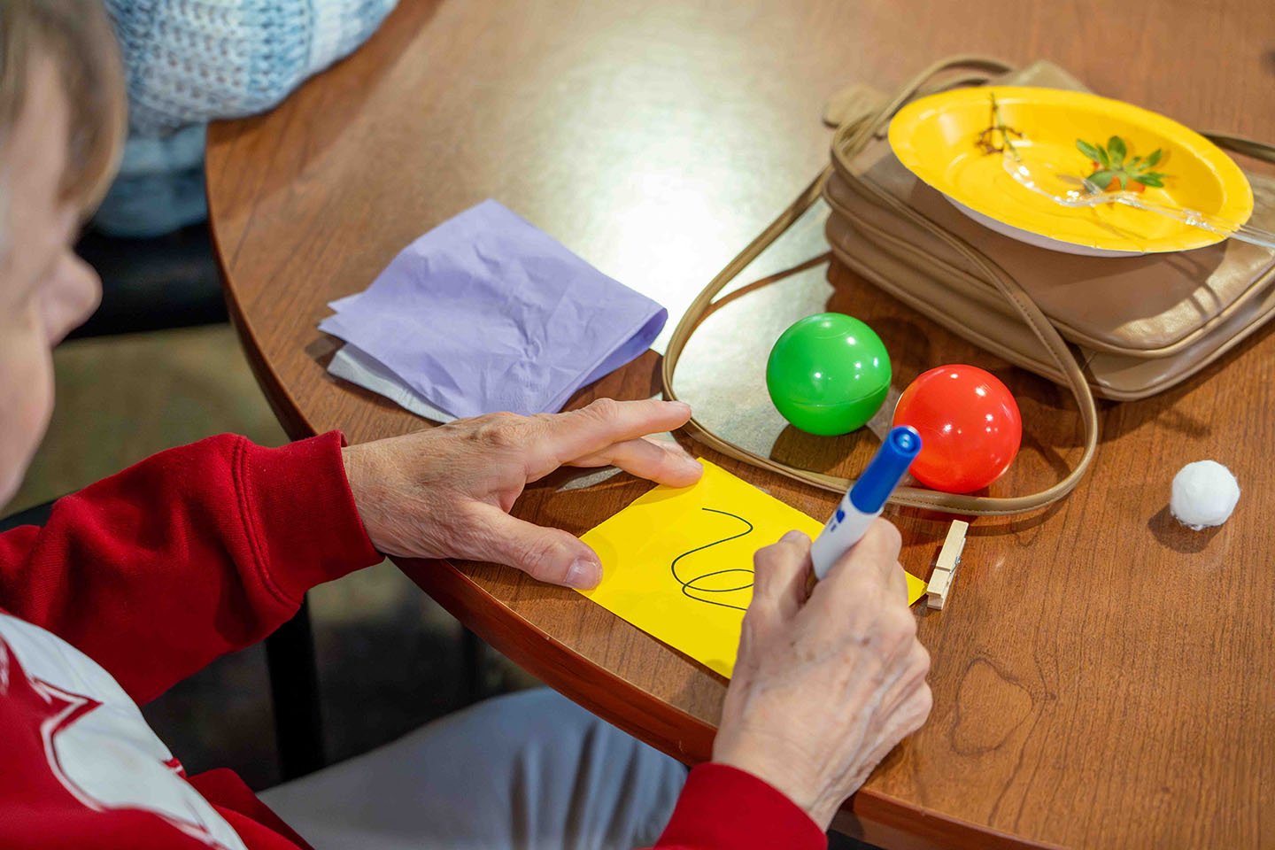 A senior woman draws during a Brain Fitness activity.