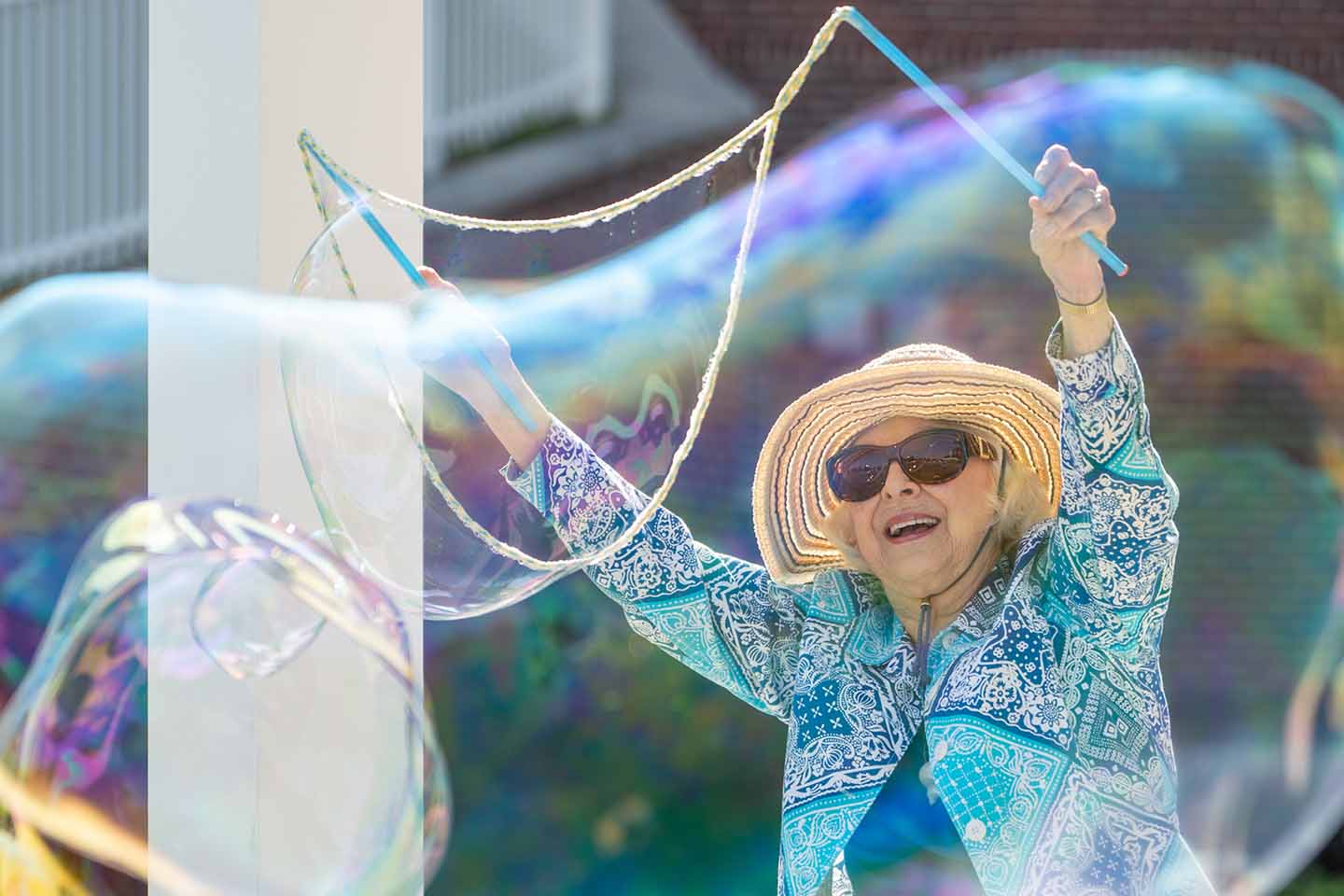 Senior woman making large bubbles. 