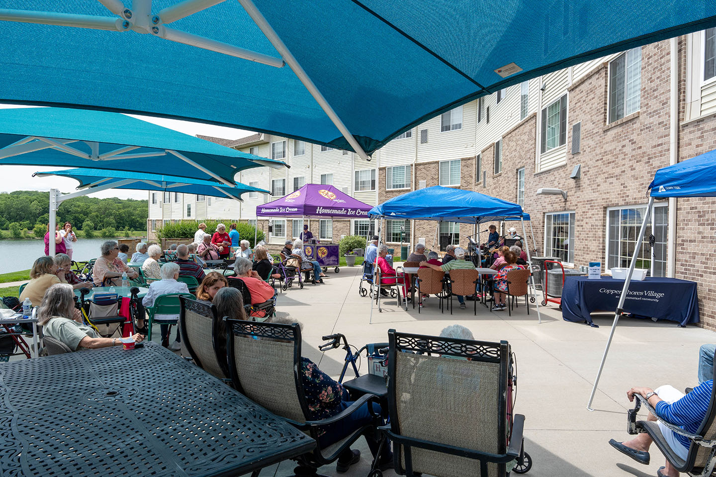 A group of seniors enjoy ice cream and live music on the patio.