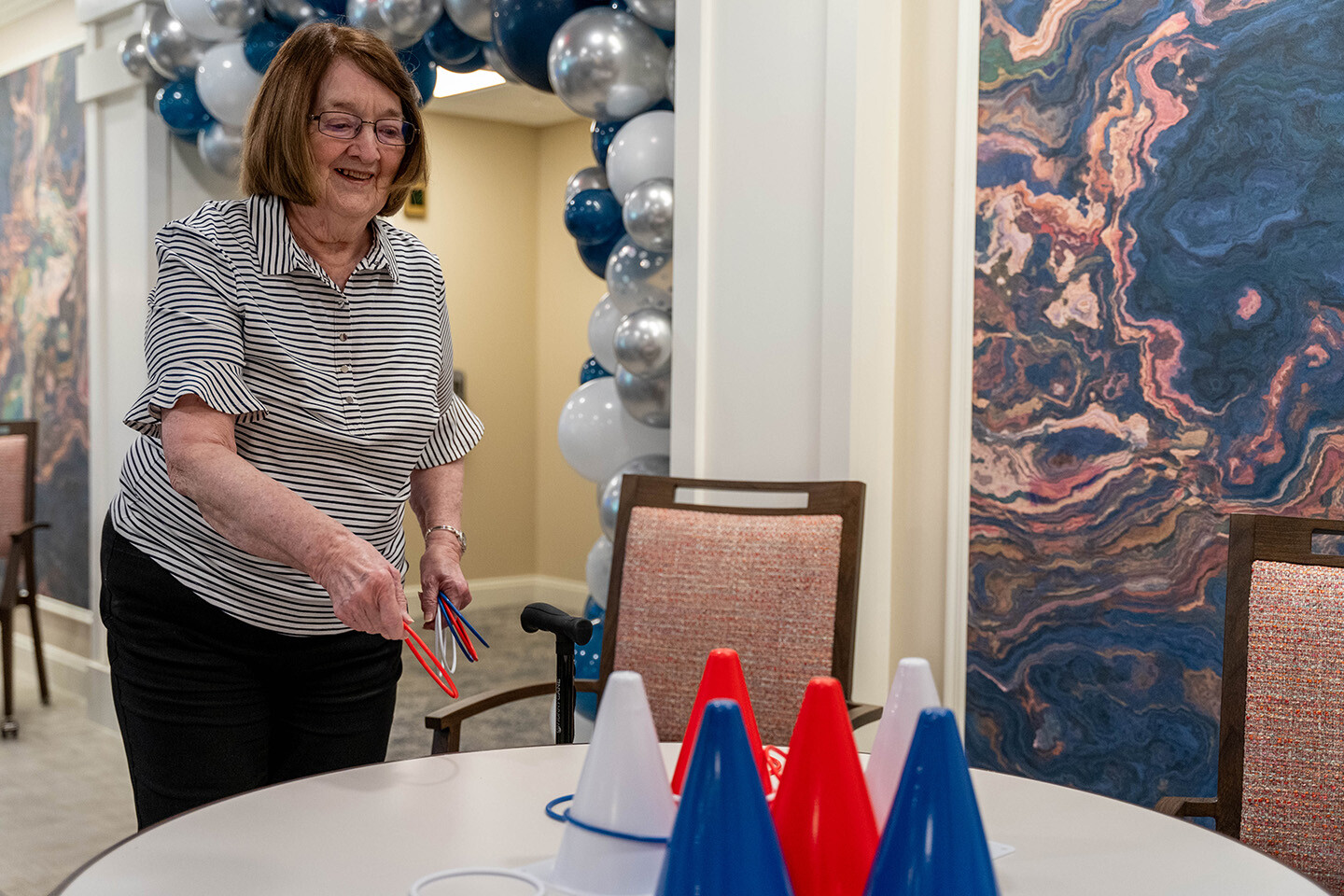 A senior woman plays a ring toss game.