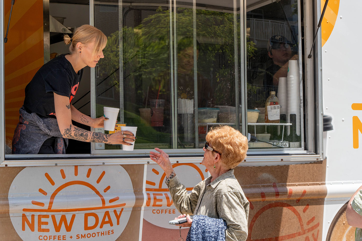  A senior woman orders a smoothie from a food truck.